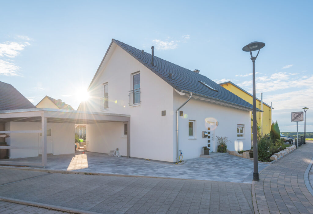 Einfamilienhaus mit Holzcarport in einer Siedlung